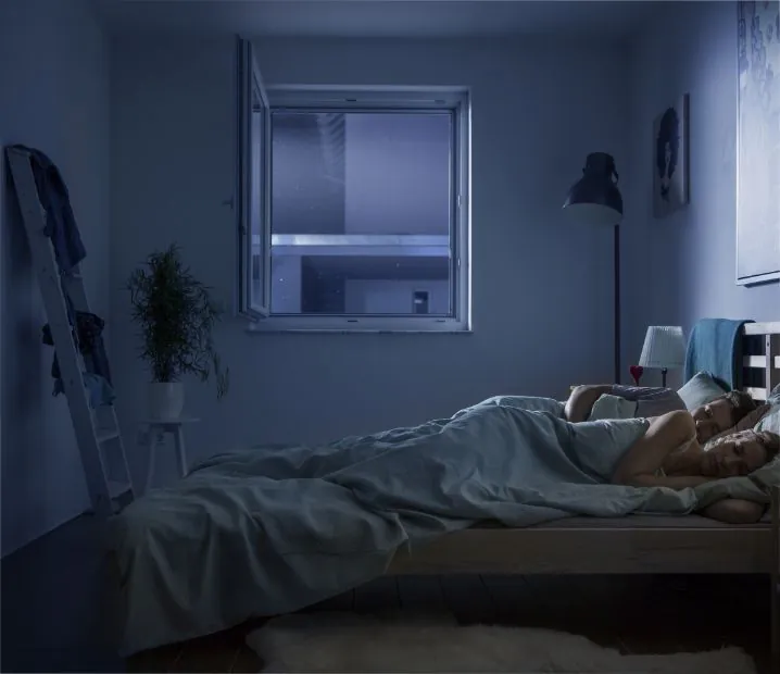 Schlafende Menschen im Schlafzimmer mit Polltec Pollenschutzgewebe am Fenster – besser schlafen dank Allergenschutz
